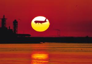 写真：松本　榮毅さん作「旭日機影　羽田空港の黎明」（海老取川河口部）